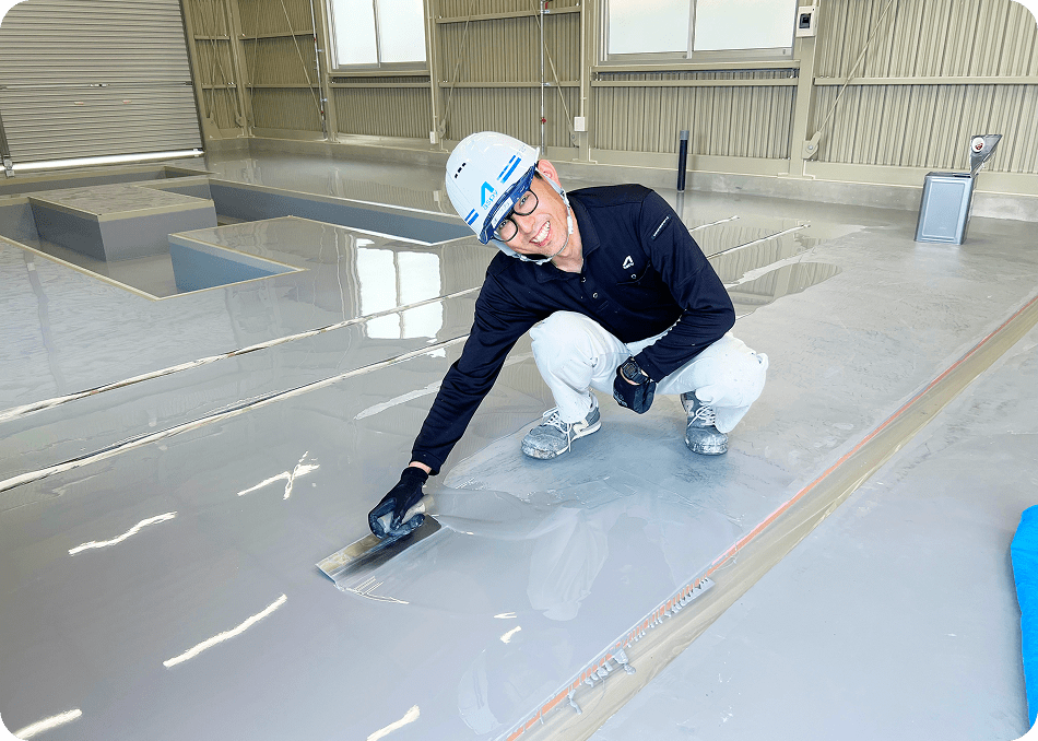 床を塗装する職人の写真